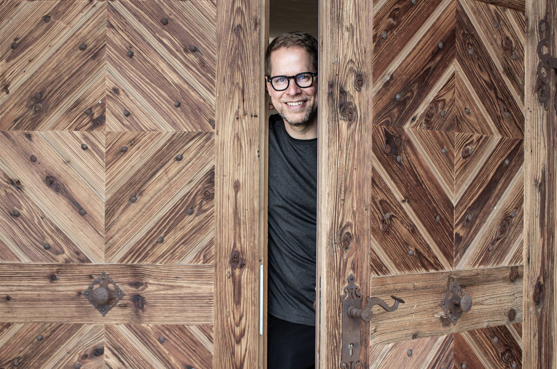 Gerold Mattersberger öffnet die traditionelle Holztür des Wellnesshotels Engel