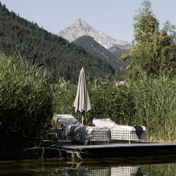 Sonnenliegen auf Holzplattformen am Bergsee des Wellnesshotels Der Engel Sonnenliegen auf Holzplattformen am Bergsee des Wellnesshotels Der Engel