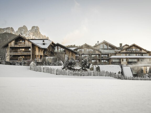 Hotelansicht von außen im Winter vom Westen - im Vordergrund die schneebedeckte Landschaft des Tannheimer Tals