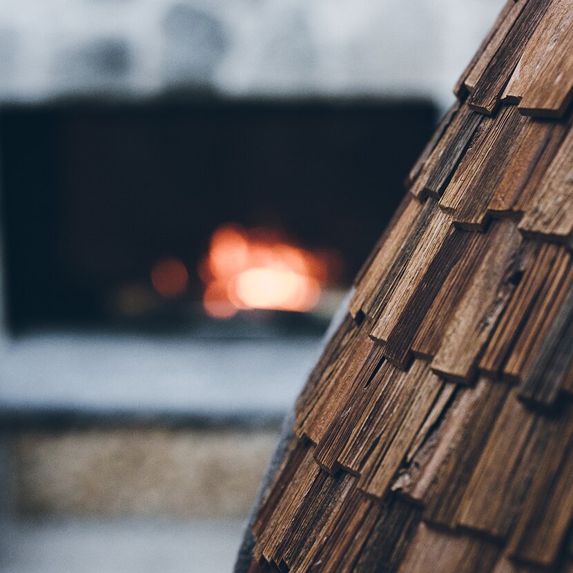 Lieblingsplatz Sitznischen mit Holzschindeln und offener Kamin mit Feuer | Der Engel in Tirol
