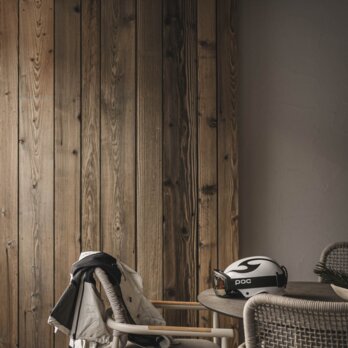 Skizeug liegt auf Outdoor-Tisch-Garnitur am Balkon der Krautgarten Suite mit Blick auf die verschneite Winterlandschaft von Grän