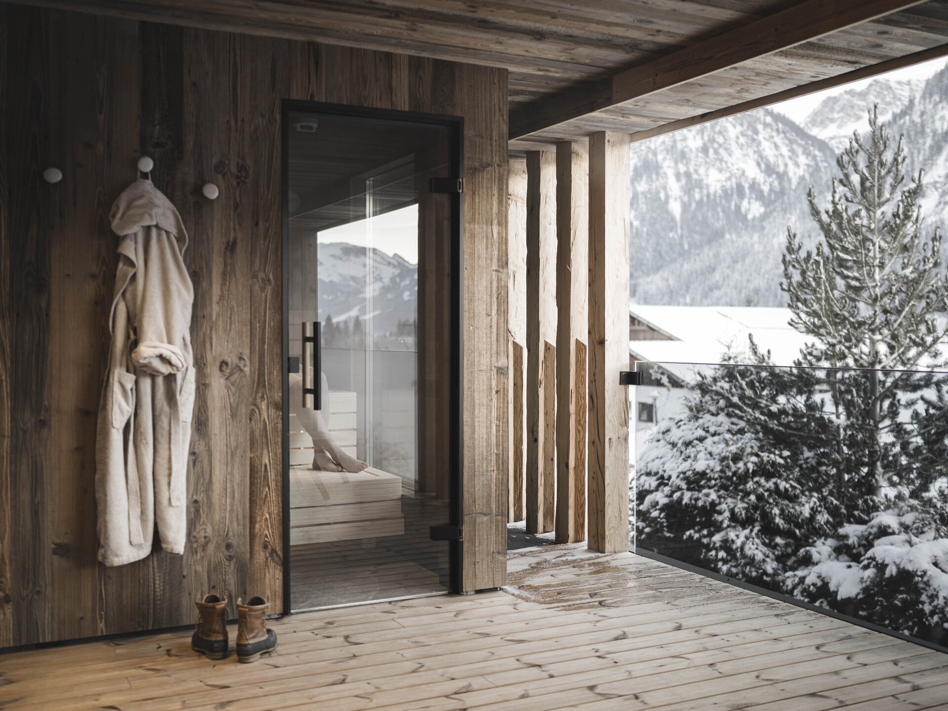 Person sitzt im Winter in der Außen-Panoramasauna der Suites am Kraut Garten