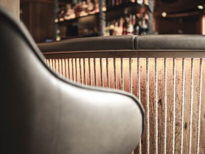 Barhocker mit Ledersessel der vor der Hotelbar steht