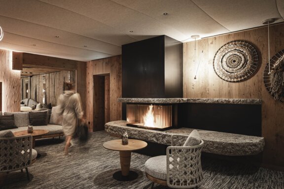 Person mit Bademantel in der Hotelbar 1748 am Kamin