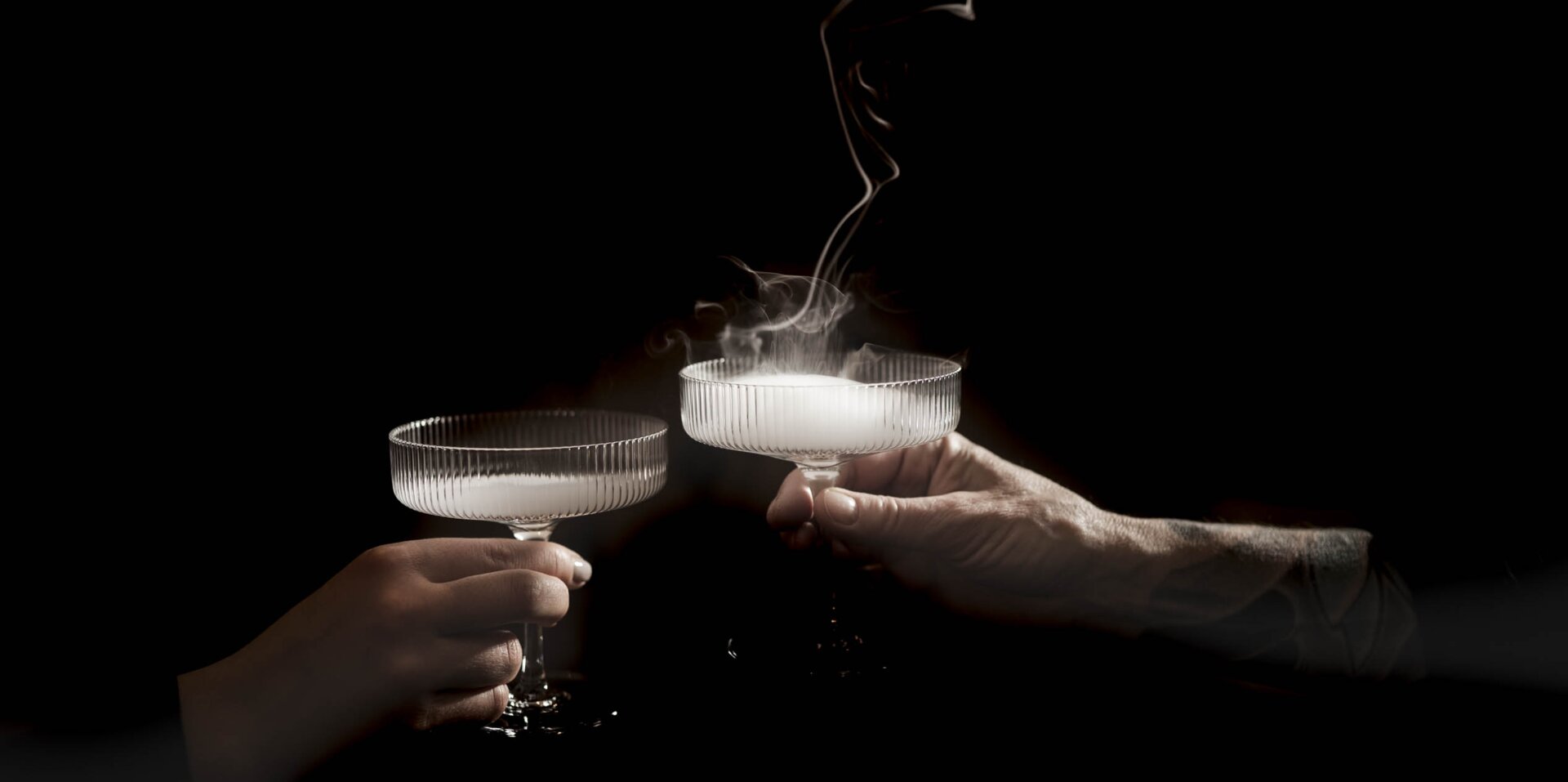 Zwei Cocktail-Gläser mit rauch vor schwarzem Hintergrund | Häppenings im Engel