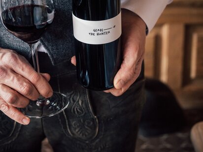 Rotwein Flasche Gerold the hunter mit gefülltem Weinglas | Der Engel in Tirol