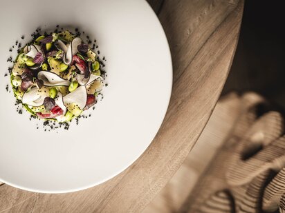 Frühlingshafte Vorspeise von Chefkoch Lukas Rettenbacher auf Holzuntergrund