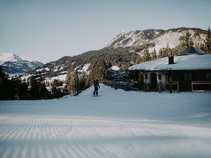 Skitourengeher auf der Piste daneben s'Um und Auf Hütte | Der Engel in Tirol