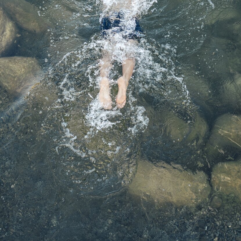 Person taucht in den Engel Bergsee ein