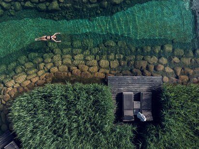 Drohnenaufnahme von Person,, die auf dem türkisen Engel Bergsee floatet