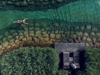 Drohnenaufnahme von Person,, die auf dem türkisen Engel Bergsee floatet