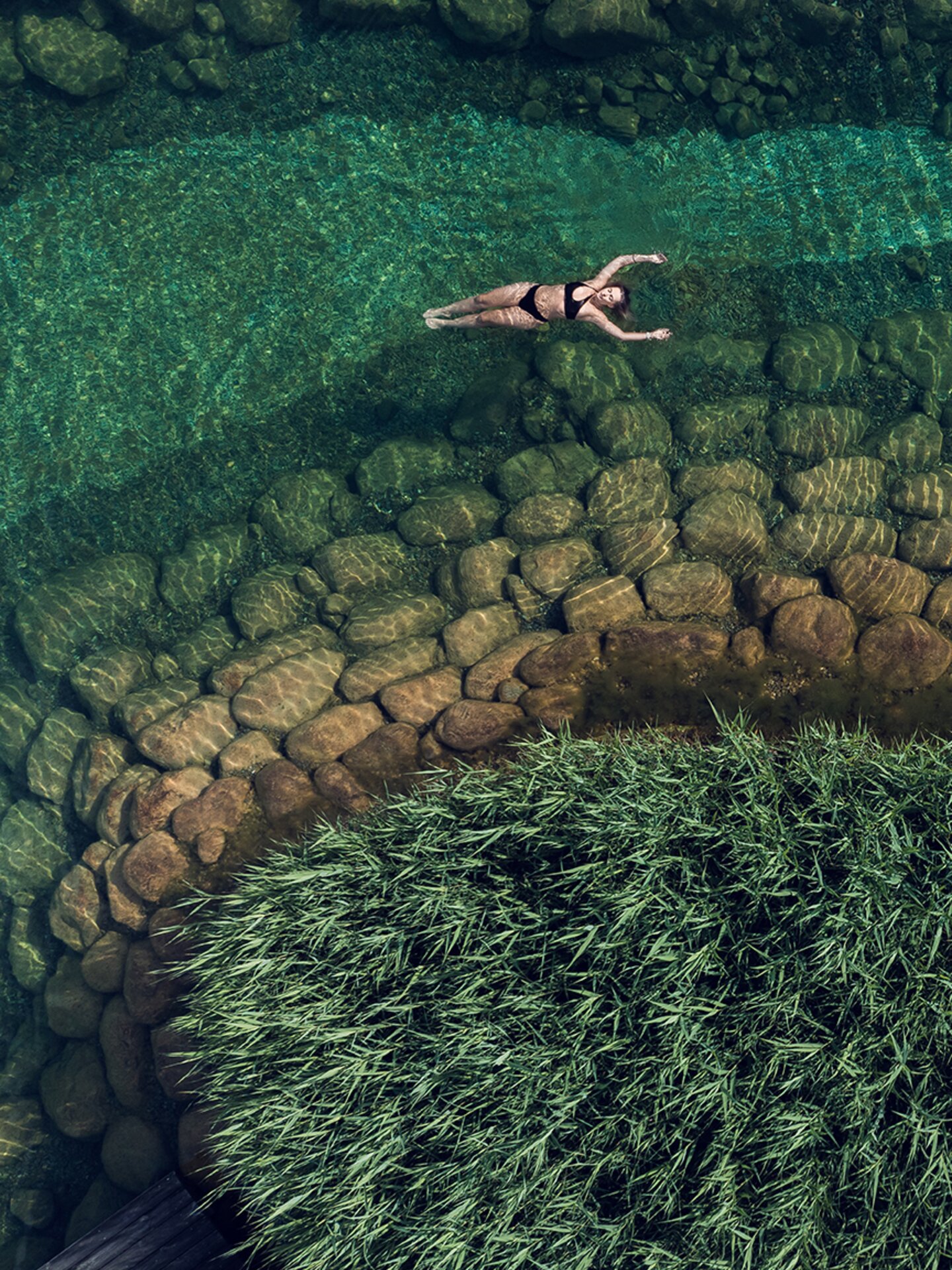 Drohnenaufnahme von Person,, die auf dem türkisen Engel Bergsee floatet