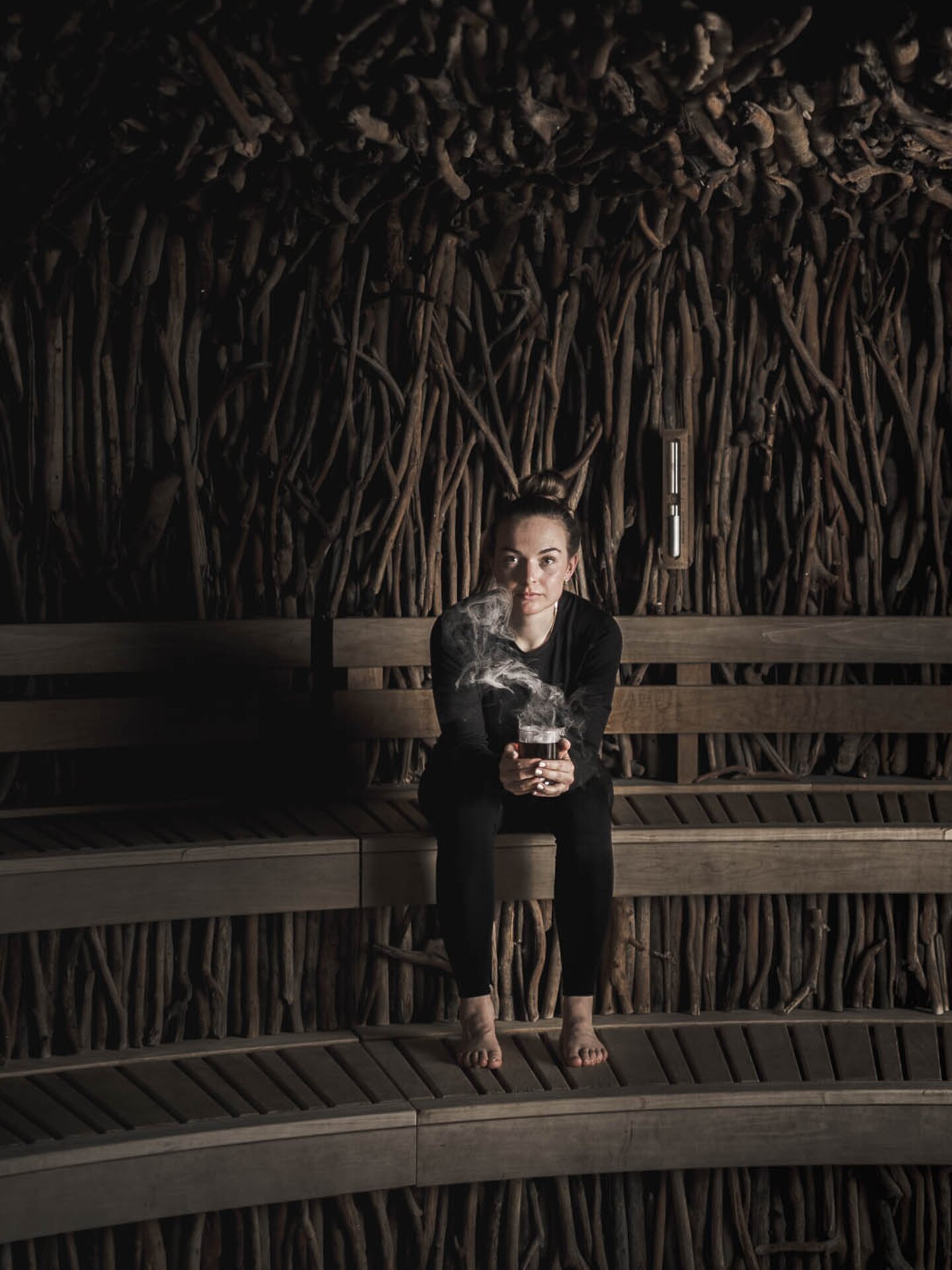 Person mit Tee in der Hand in Skiunterwäsche in Sauna 
