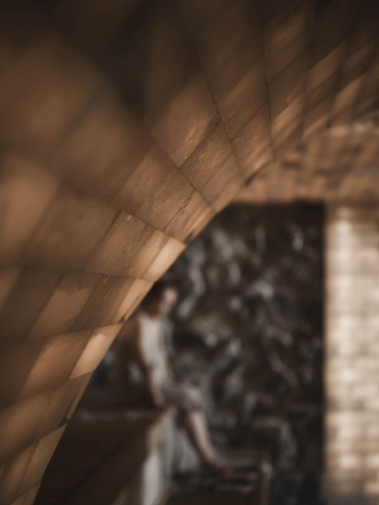 Person sitzt in Salzgrotte beim Saunaaufguss mit Saunahandtuch