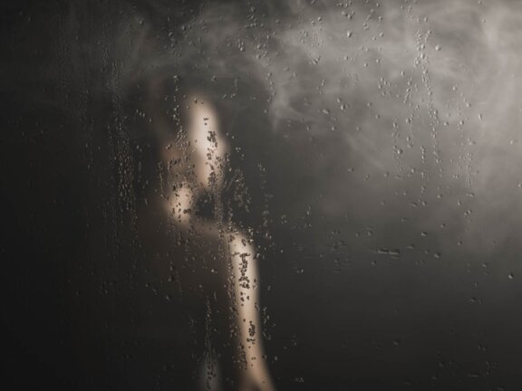 Gast steht mit Handtuch umwickelt in der Sauna und man sieht den Dampf afgehen