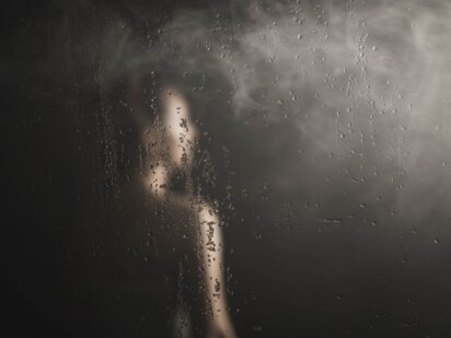 Gast steht mit Handtuch umwickelt in der Sauna und man sieht den Dampf afgehen