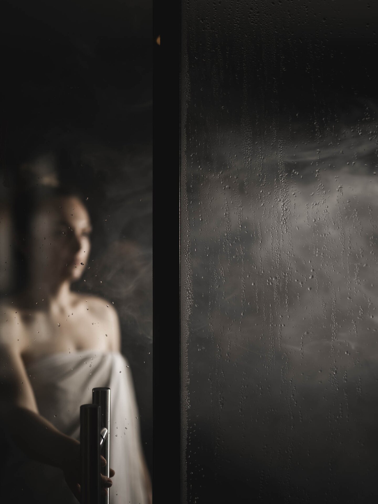 Person mit Saunahandtuch steht in Dampfsauna im Wellnesshotel Der Engel