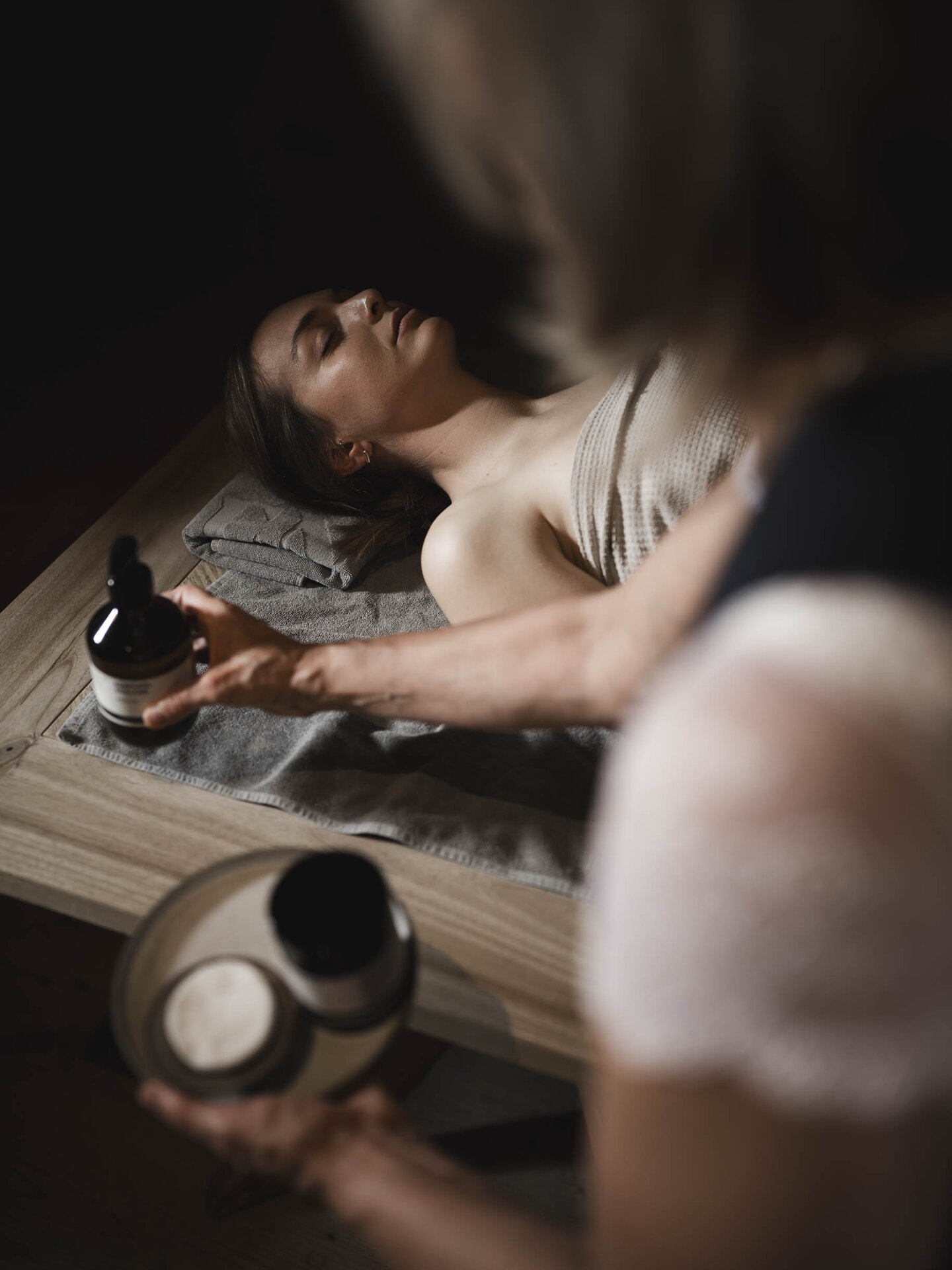 Person beim Orgänic Treat im Vordergrund Wellness-Spezialistin mit Orgänic Zusätzen für die Massage