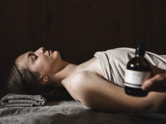 A person lying on a treatment bed for a body wrap at Wellnesshotel Der Engel