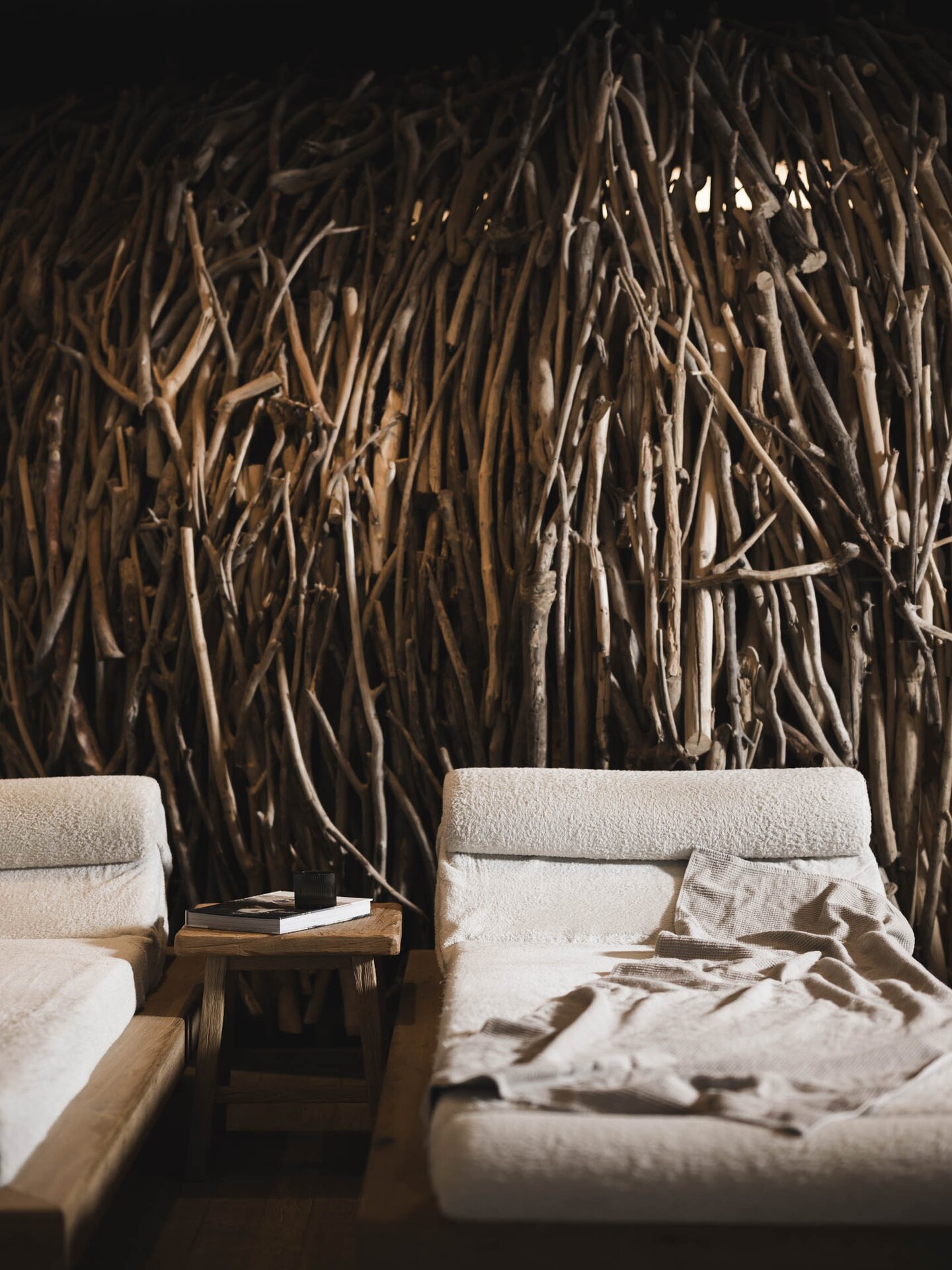 Design-Ruheliegen im Raum der Stille die Wand wird von Treibholz aus dem Lech dekoriert