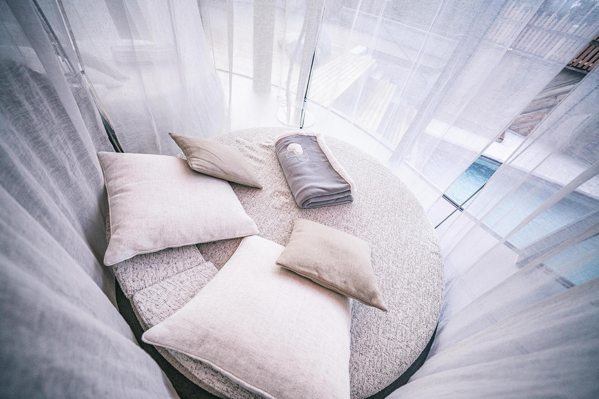 Kuschelnest im Pure Organic Spa mit Vorhang und Ausblick auf den Entspannungspool | Der Engel in Tirol