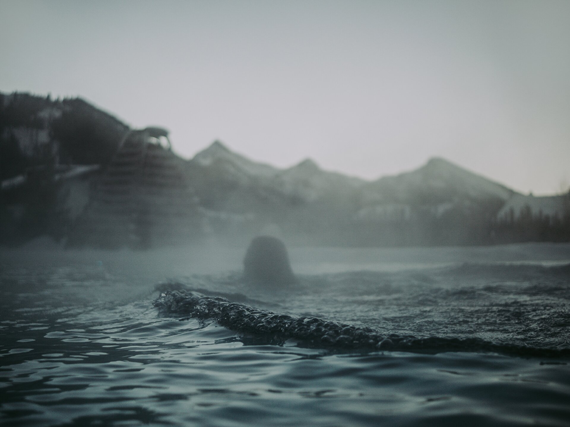 Schwimmer im Außenpool mit Wasserdampf im Winter | Der Engel in Tirol