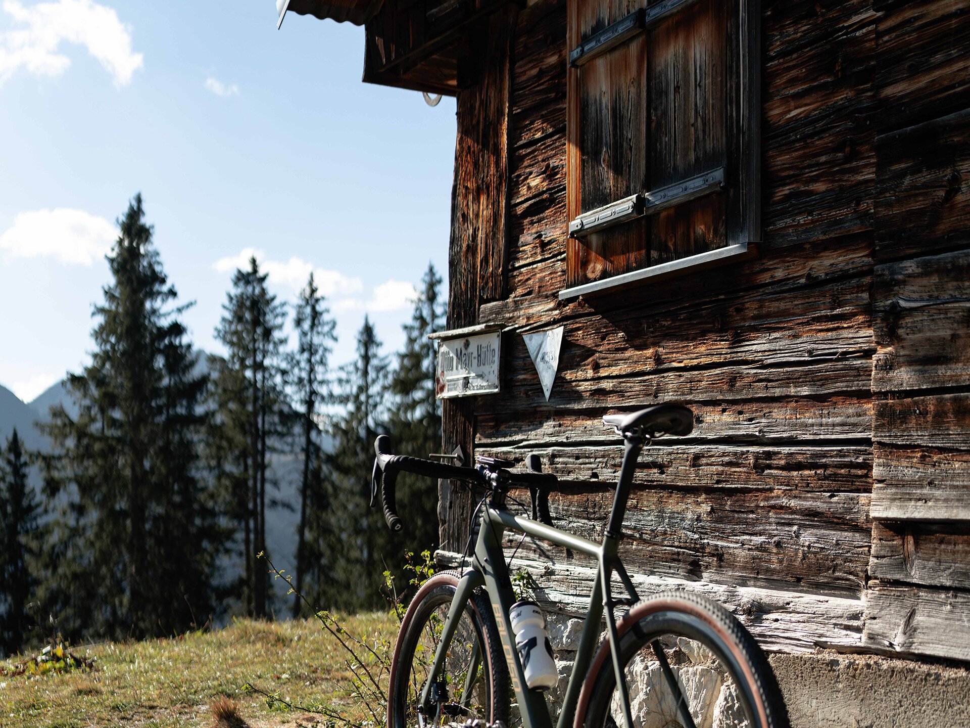 Gravelbike vor alter Holzhütte am Berg im Tannheimer Tal