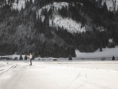Stehende Langläuferin auf der Skatingloipe im Tannheimer Tal, Grän