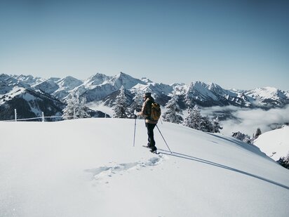 Person beim Schneeschuhwandern in den Allgäuer Alpen bei frischem Neuschnee und blauem Himmel | Der Engel in Tirol