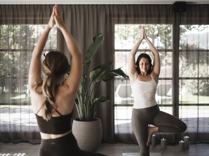 Zwei Personen bei einer Yogastunde im Yogaraum im Wellneshotel Der Engel