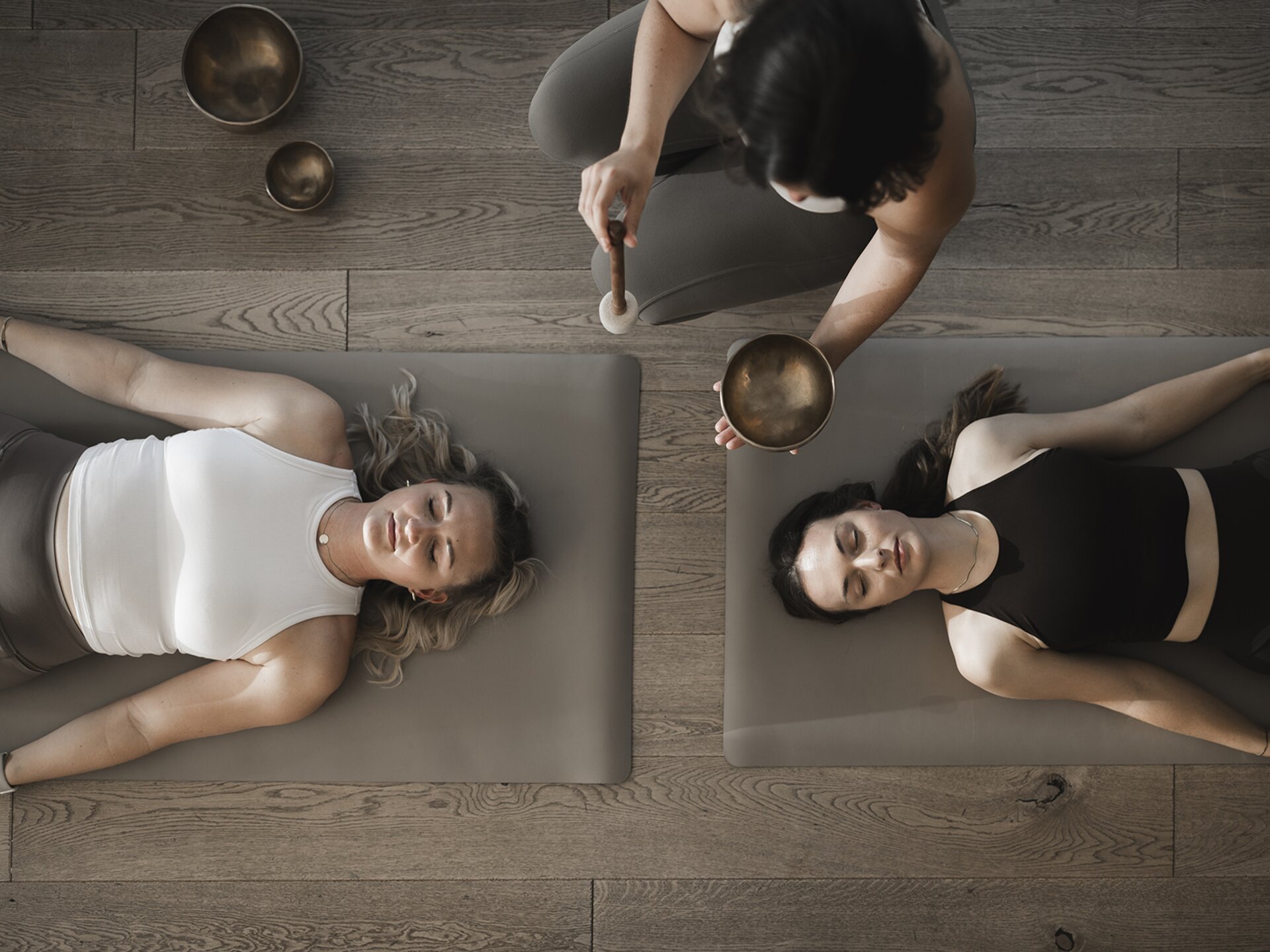 Zwei Personen liegend auf einer Gymnastikmatte bei einer Klangmeditation im Wellnesshotel Der Engel
