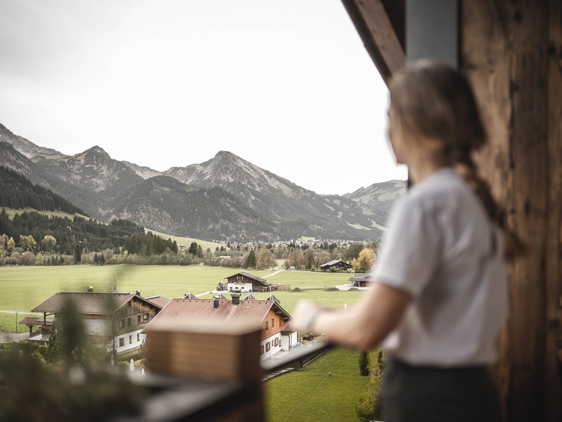 Person steht am Balkon eines Orgänic Zimmers mit Blick auf das Tannheimer Tal