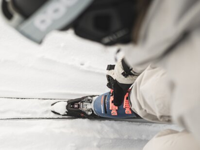 Skifahrerin schließt Skischuhe - Vogelperspektive