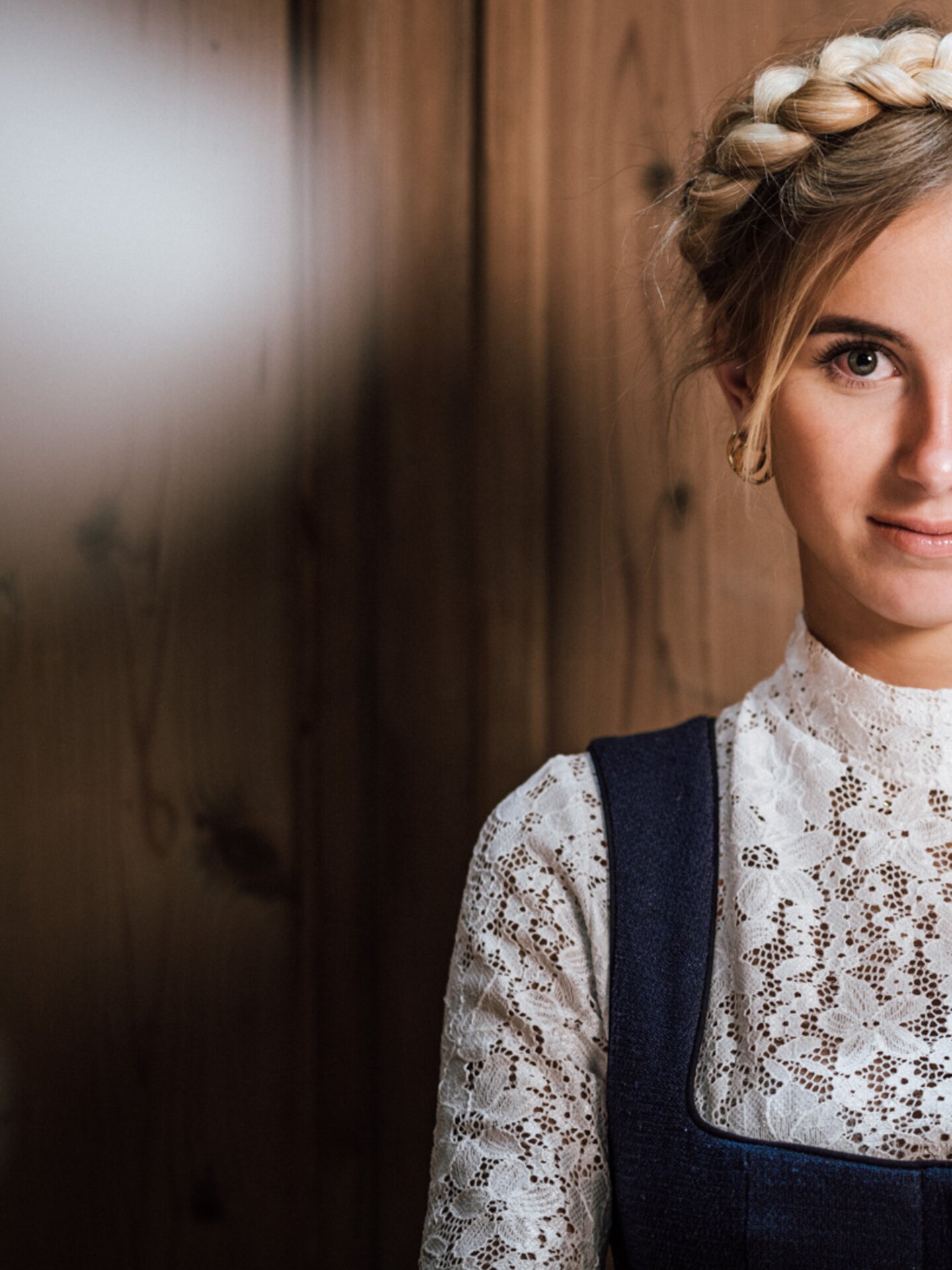 Frau im traditionellen Tiroler Dirndl in blau mit weißer Spitzenbluse in einer Tiroler Holzstube | Der Engel in Tirol