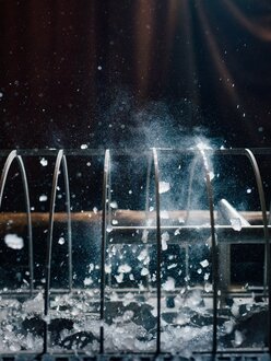 Saunameister beim Saunaufguss, Wasser wird über Saunaofen gegossen | Wellnesshotel Der Engel