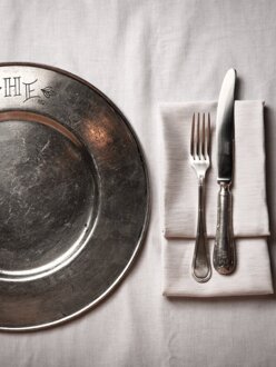 Alter Unterteller aus Metall auf weißer Leinentischdecke | Hotel Der Engel